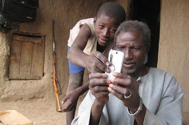 alaburu-maiga-right-tries-to-use-the-camera-on-his-cell-phone-with-the-help-of-an-unidentified-boy-in-the-village-of-gono-mali