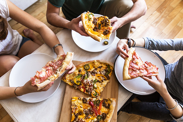 Group of people eating pizza.