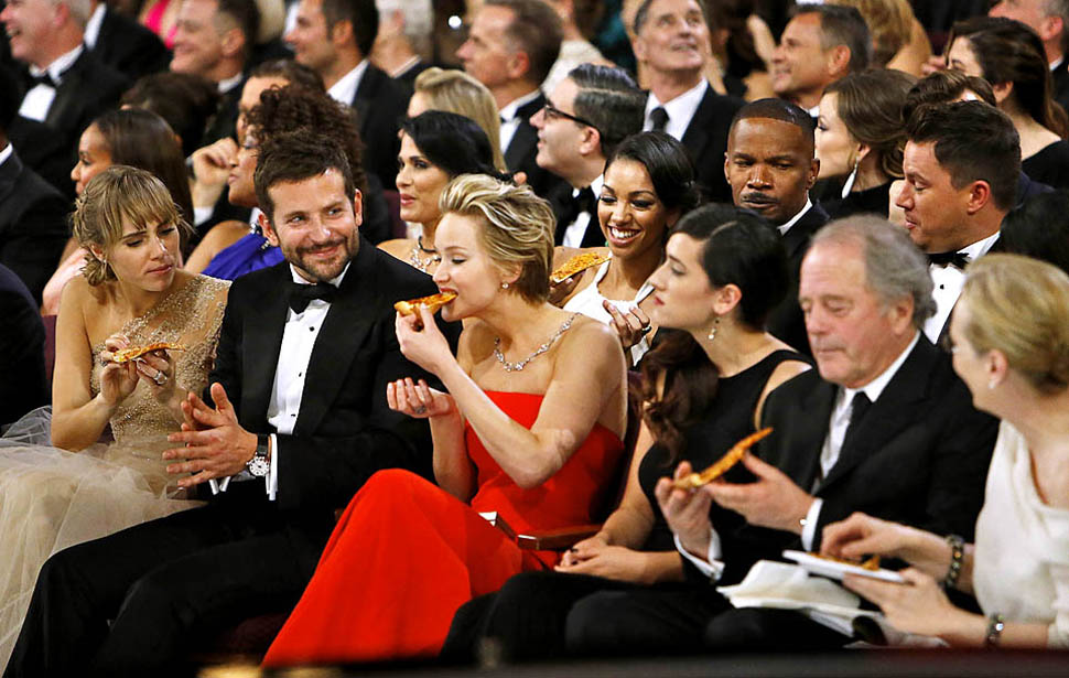 Jennifer Lawrence eats and Bradley Cooper looks on.