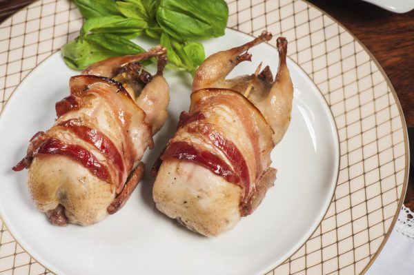 Two fried quails with bacon